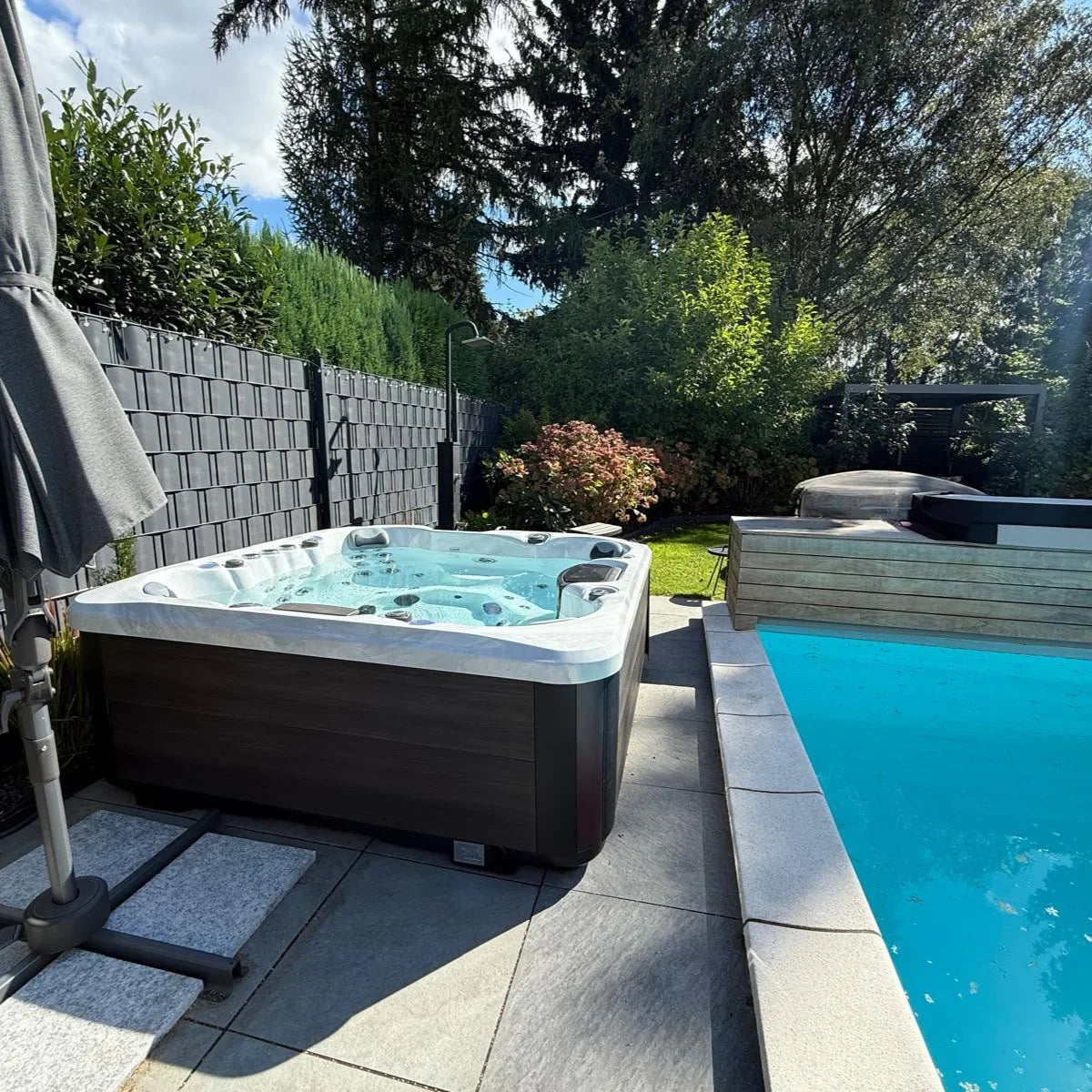 Moderner Outdoor Whirlpool im Garten mit Pool, luxuriöse Wellness-Atmosphäre, elegantes Design