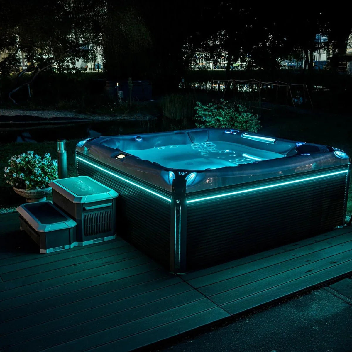 Luxuriöser Wellis Outdoor Whirlpool mit LED-Beleuchtung auf Terrasse im nächtlichen Garten