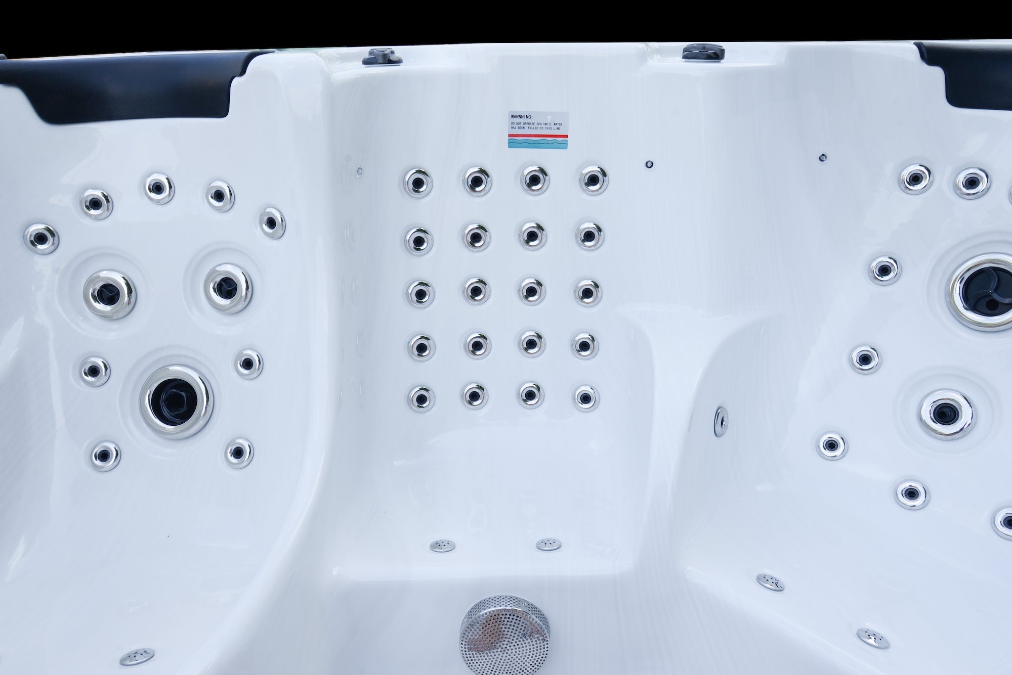 Nahaufnahme der Massagedüsen im weißen Innenbereich des New Wave Elite Pro 590 Swim Spa mit rutschfester Oberfläche.