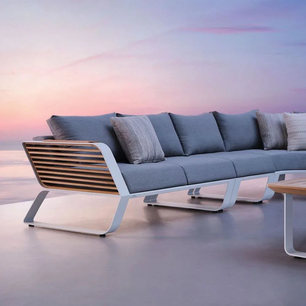 Luxuriöse Higold Garten Ecklounge aus Aluminium und Holz auf moderner Terrasse, Sonnenuntergang, Outdoor Wellness-Atmosphäre
